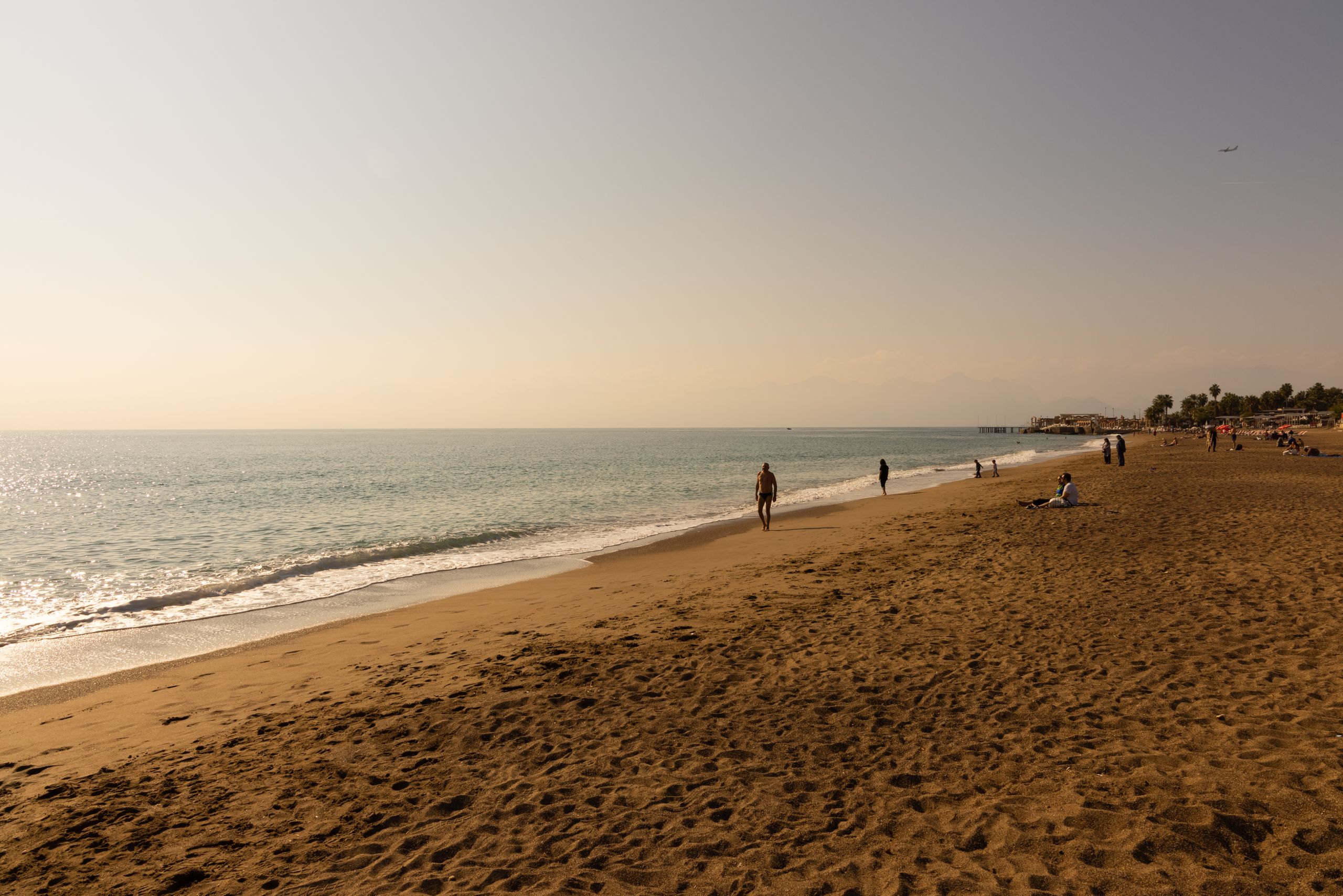 A serene beach scene with people enjoying a warm day by the shore, perfect for travel and lifestyle themes.